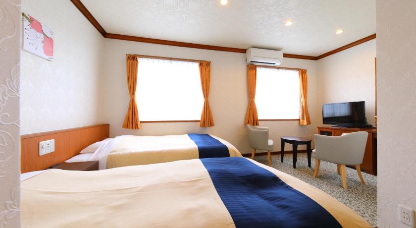 a hotel room with a bed and a television, Hotel Star in Beppu