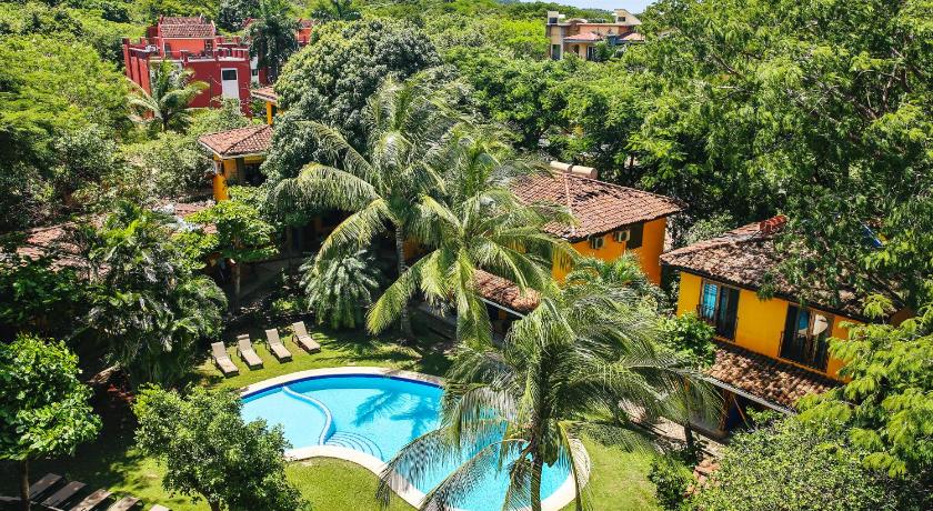 a lush green beach with palm trees and palm trees, Villas Macondo in Tamarindo