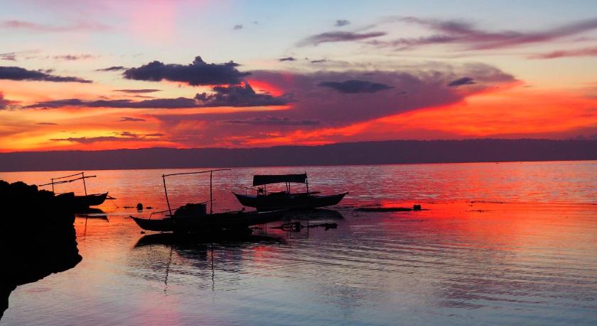 two boats are docked in the water at sunset, Weyh's Studio #1 by the ocean in Bohol