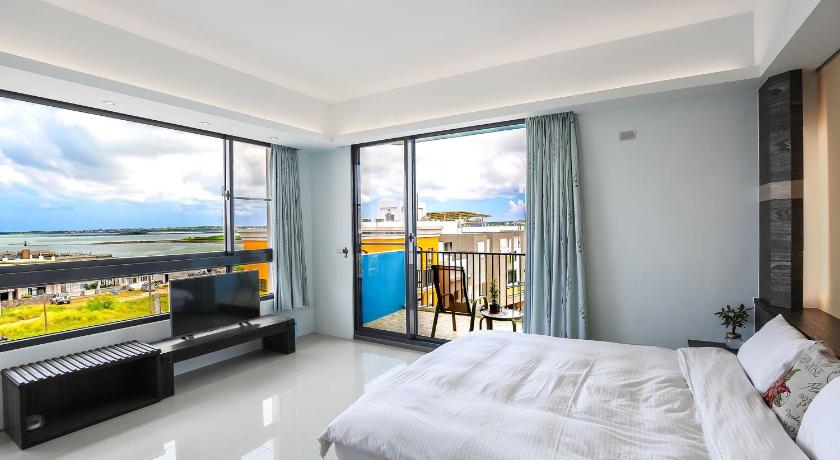 a hotel room with a large bed and a large window, Jhong Sia Yuan B&B in Penghu