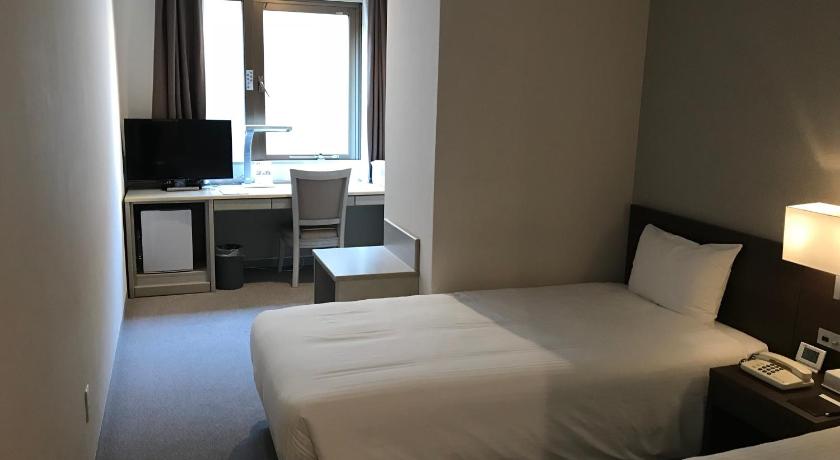 a hotel room with two beds and a television, Chisun Hotel Kamata in Tokyo