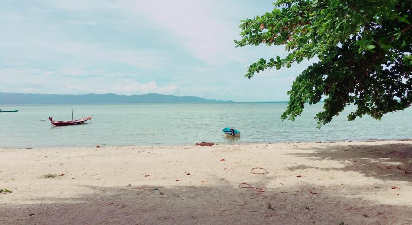 a beach scene with a boat and some trees, Blue Lotus Resort in Ko Pha-ngan