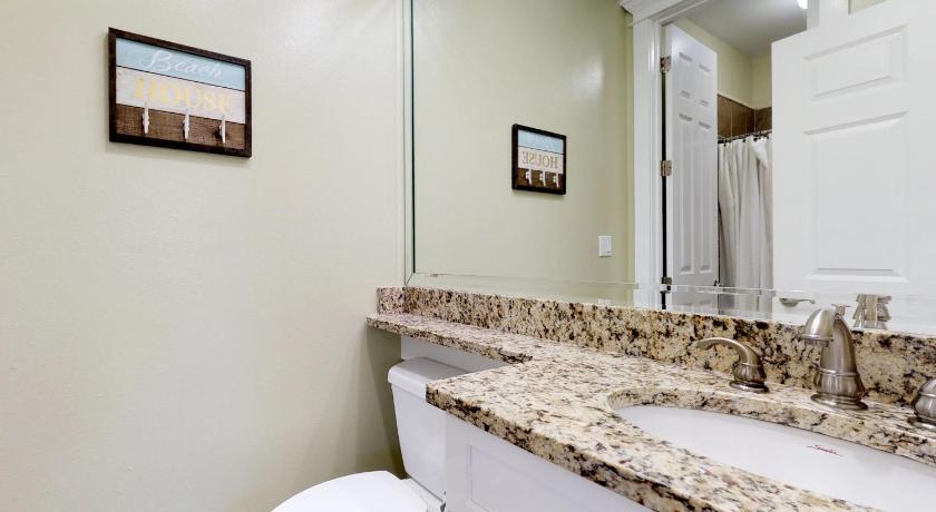 a bathroom with a toilet, sink and mirror, Miramar Beach Villas #110 in Destin (FL)