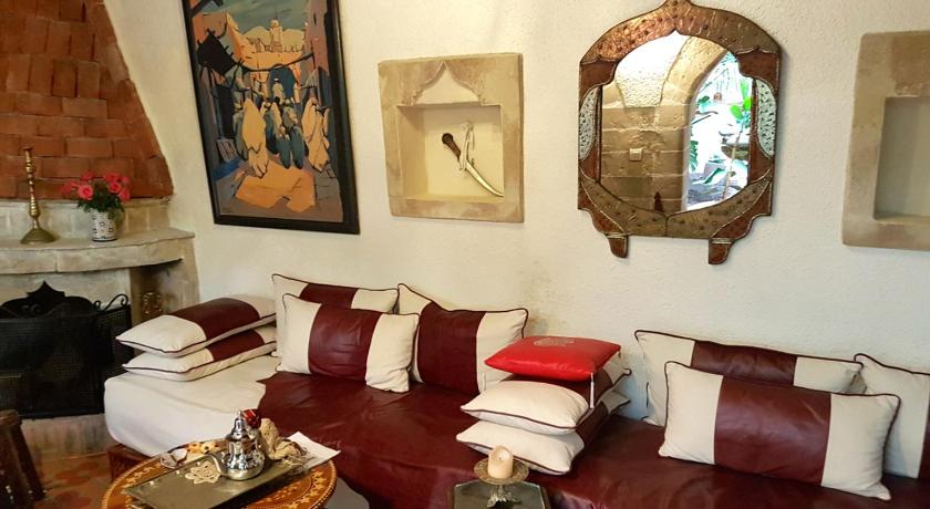 a living room filled with furniture and a painting on the wall, Riad Arambys in Essaouira