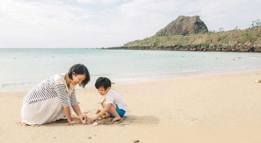 two women sitting on a beach next to a body of water, Caesar Park Hotel Kenting in Kenting