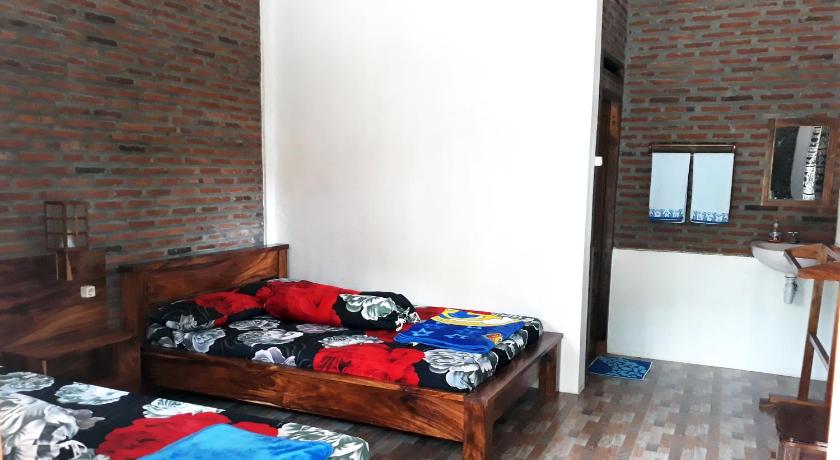 a bed room with two beds and a wall, Ragha Homestay in Pangandaran
