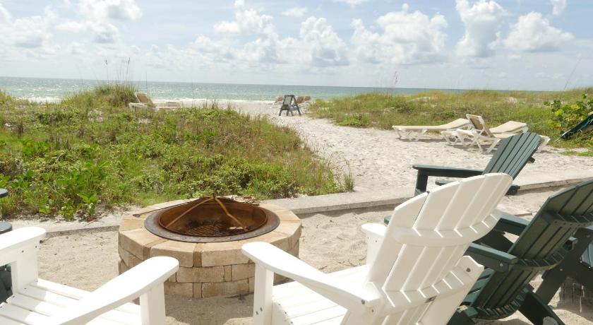 a bench sitting on top of a beach next to a body of water, Sand Glo Villas in Indian Shores (FL)