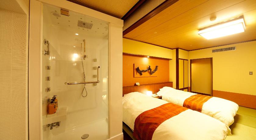 a hotel room with a bed and a shower, Tosa Gyoen Hotel in Kochi