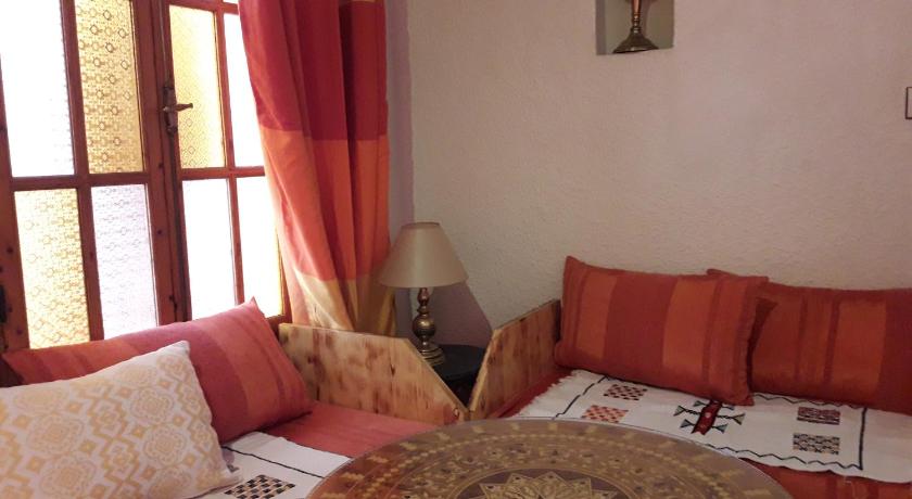 a room with a bed, table, lamp and window, Riad Arambys in Essaouira