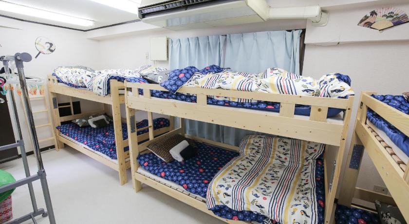 a row of bunk beds in a room, Station Condominium Otsuka in Tokyo