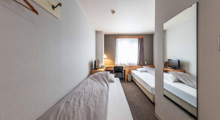 a hotel room with a bed and a desk, Business Hotel Hanaya in Tanabe