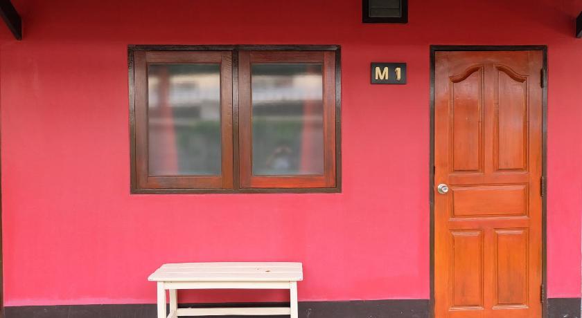 a red chair sitting in front of a red door, Baan Ma Feung Guest House in Kanchanaburi