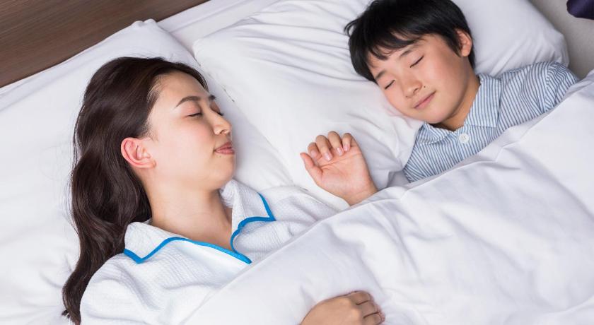 a man and a woman laying on a bed, Comfort Inn Omihachiman in Omihachiman