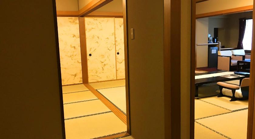 a living room with a door open to a hallway, Kannawa Onsen Oniyama Hotel in Beppu
