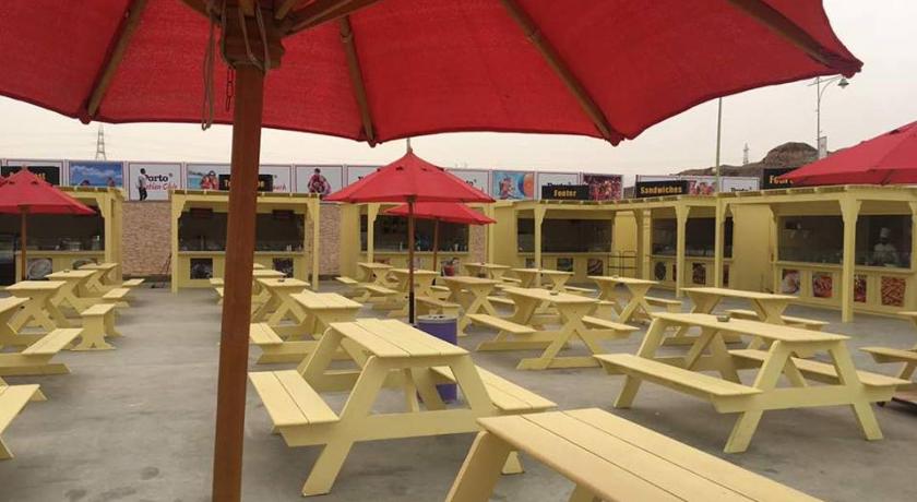 a patio area with tables, chairs and umbrellas, شاليهات عائلية صف اول علي البحر مباشرة in Ataqah
