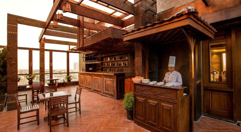 a kitchen with wooden floors and a large window, The Home Hotel in Mandalay