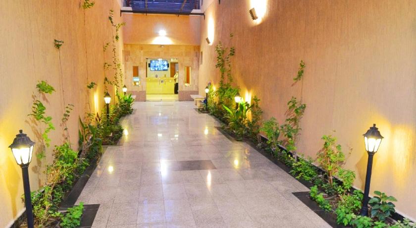 a walkway that has a lot of plants in it, dalla house suites in Dammam