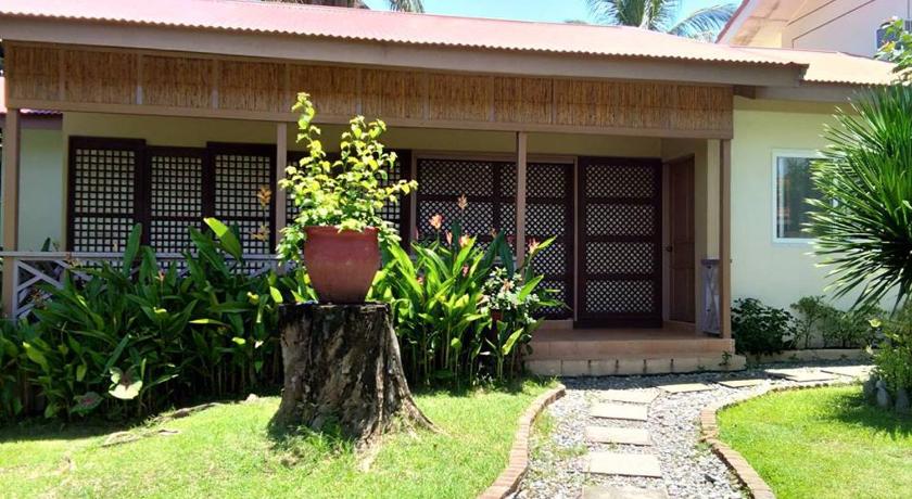 a garden area with a tree and shrub in front of a house, Happy Ripples Beach Resort in San Fabian