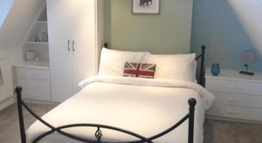 a bedroom with a white bed and white walls, Kenilworth Cosy Castle View Apartment in Birmingham