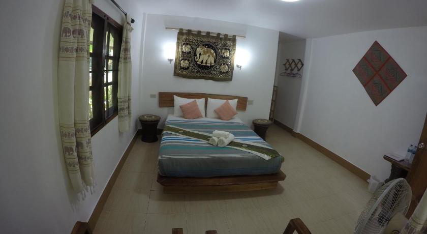 a room with a bed, a chair, and a window, Khao Sok Holiday Resort in Khao Sok (Suratthani)