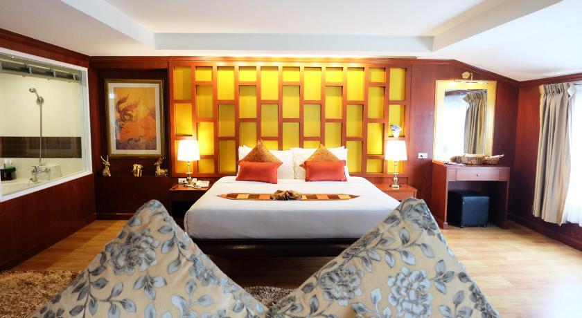 two beds in a room with a white bedspread, Grand Hill Resort and Spa in Nakhon Sawan