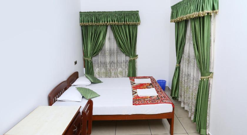 a bedroom with a bed and a dresser, kevins Placid Homestay in Kochi