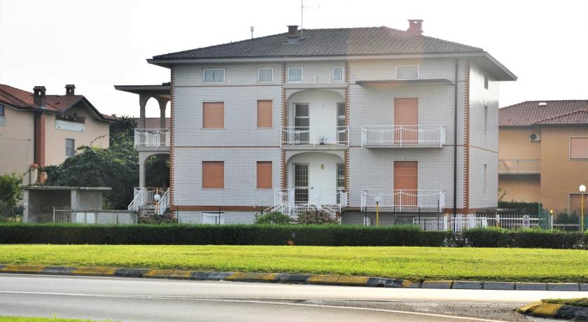 a large white house sitting in front of a building, Villa Giulia in Bonate Sopra