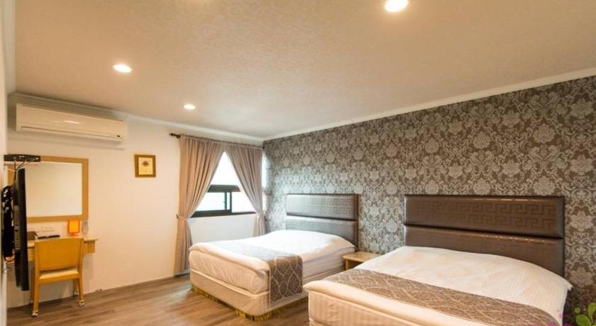 a hotel room with a bed and a tv, Yilan Jimmy Villa in Yilan