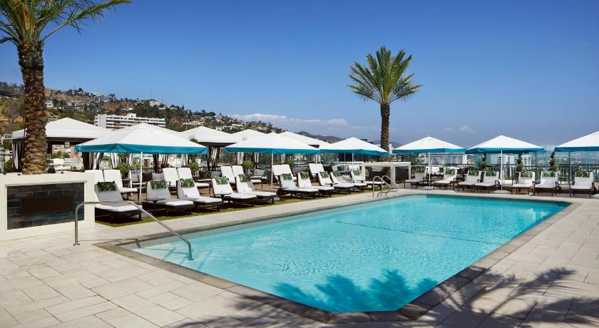 a beach area with a pool, chairs, and umbrellas, The London West Hollywood at Beverly Hills in Los Angeles (CA)