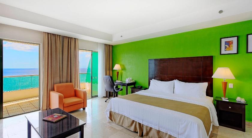 a hotel room with a large bed and a large window, Holiday Inn Campeche in Campeche