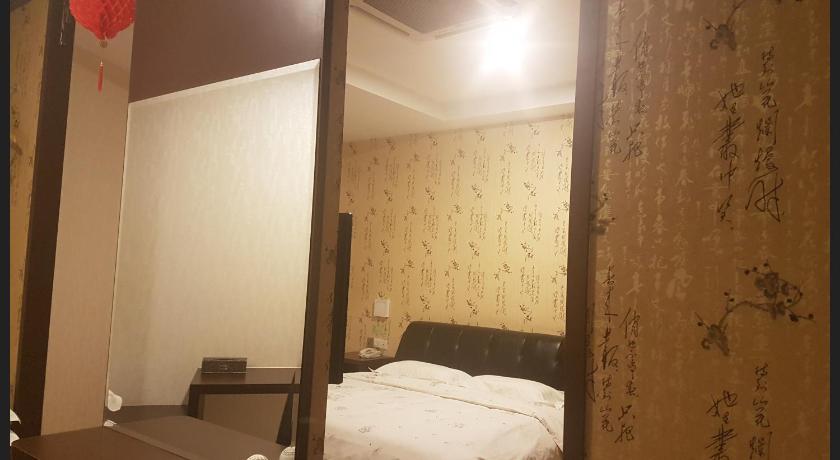 a bedroom with a bed and a lamp, Hotel Tebrau CT in Johor Bahru