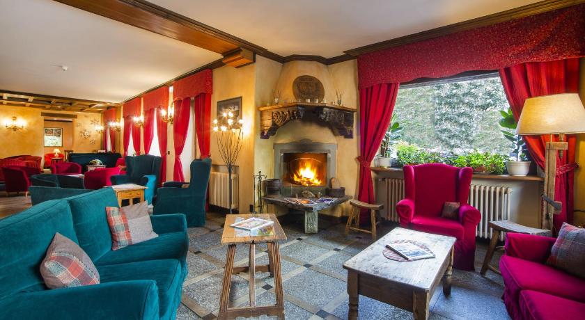 a living room filled with furniture and a fire place, Hotel Courmayeur in Courmayeur