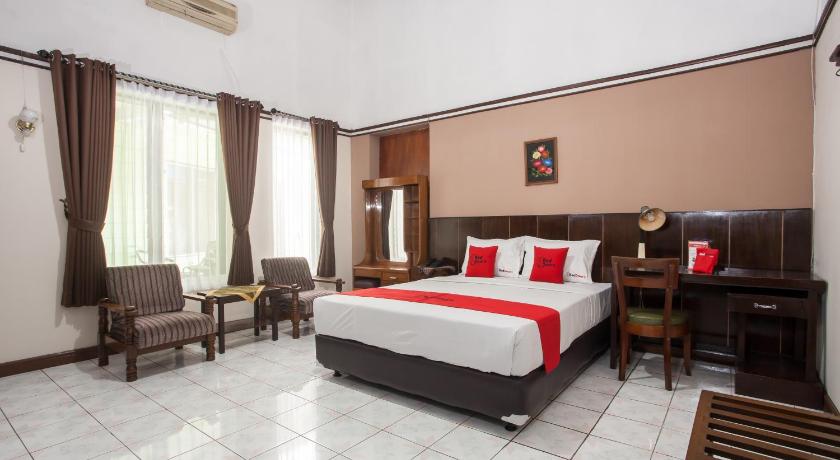 a hotel room with two beds and a table, RedDoorz near Balai Kota Malang in Malang