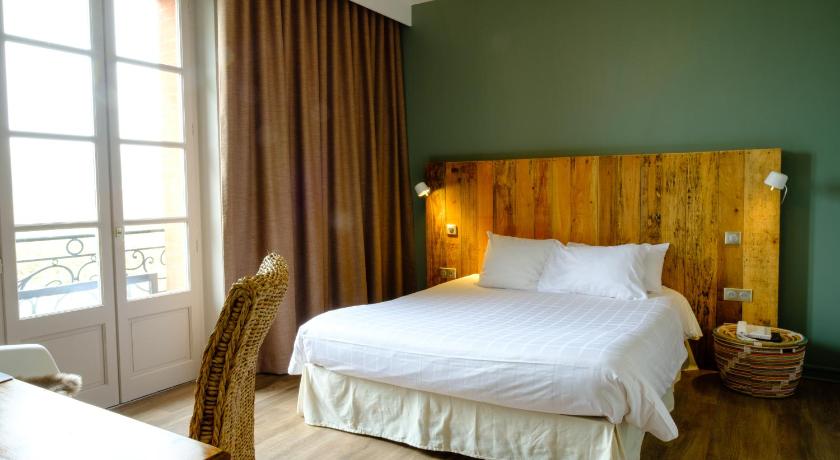 a bedroom with a large bed and a large window, Hotel Le Moulin de Moissac in Moissac