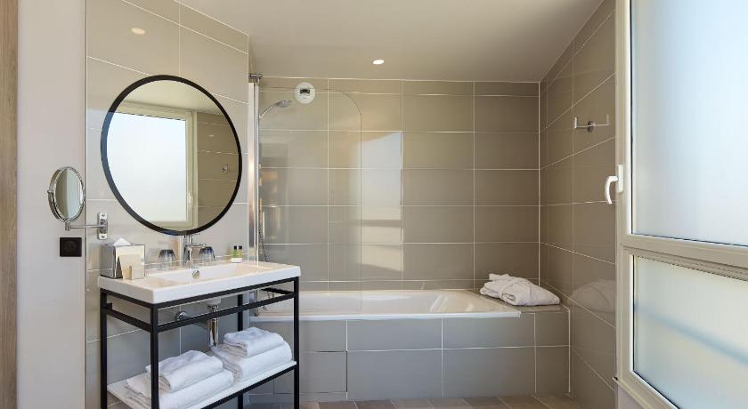 a bathroom with a tub, sink, mirror, and bathtub, Auteuil Tour Eiffel Hotel in Paris