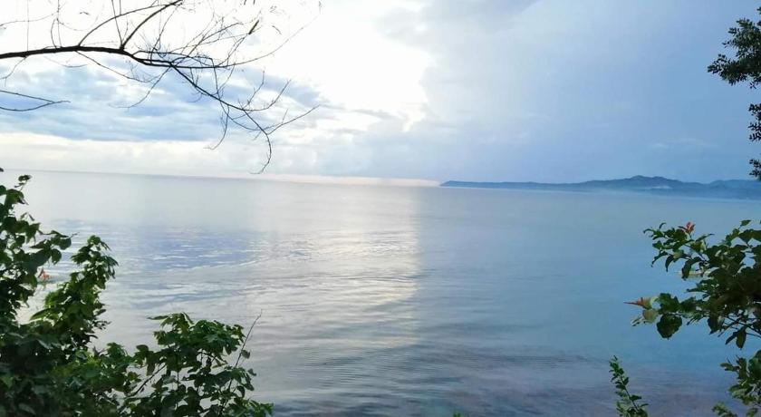 a body of water with trees and a sunset, Bohol Lahoy Dive Resort in Bohol