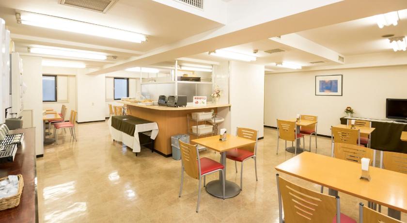 a room with a table, chairs, and a refrigerator, Hashimoto Park Hotel in Sagamihara