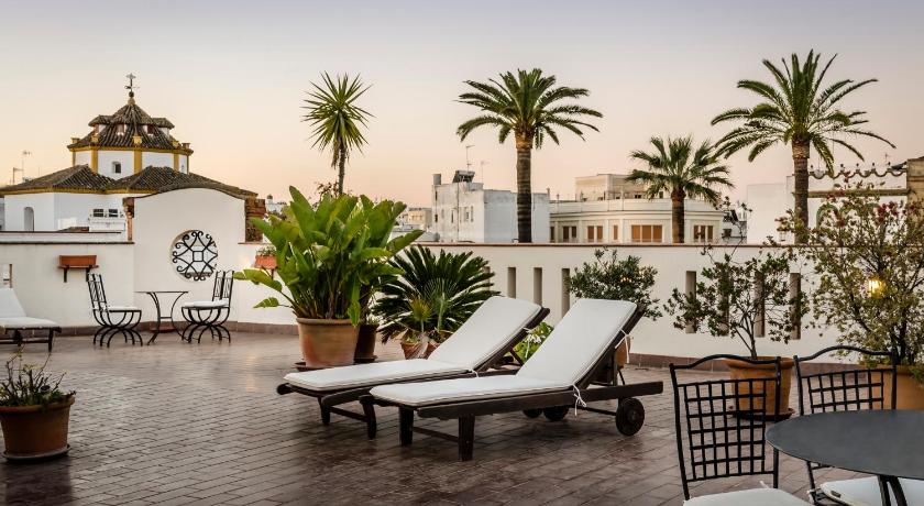 a patio area with chairs, tables, and tables with umbrellas, Hotel YIT Casa Grande in Jerez de la Frontera