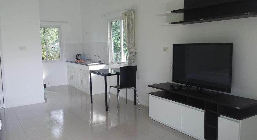 a kitchen with a table and chairs and a tv, Thipburee Resort in Nakhon Si Thammarat