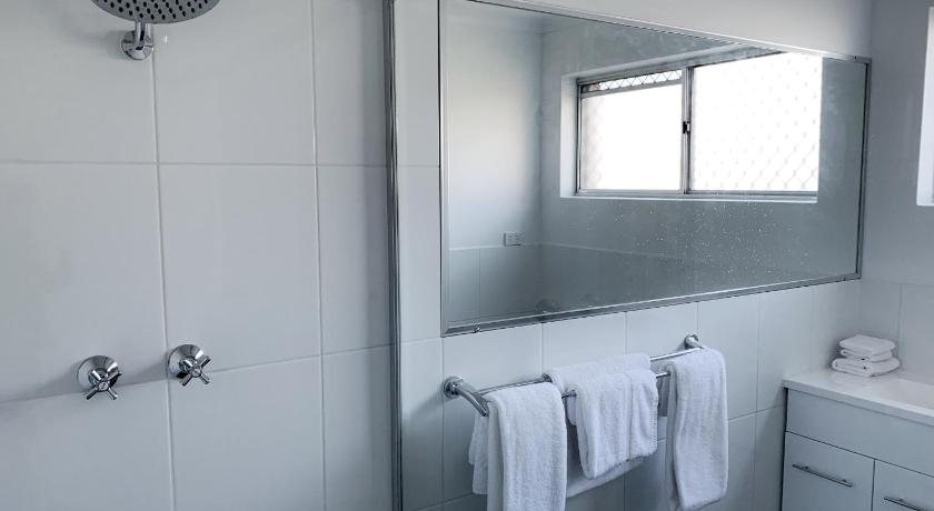a bathroom with a shower, sink, and mirror, Cascades Motor Inn in Dubbo