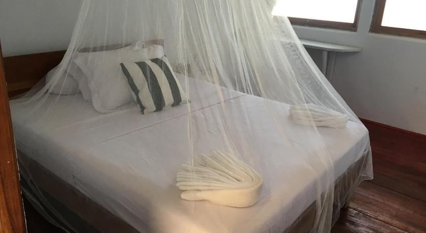 a bed that has a blanket on it, Bajo Sunset Hostel in Labuan Bajo