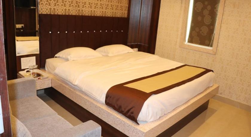 a hotel room with two beds and a mirror, Hotel Angina in Kolkata