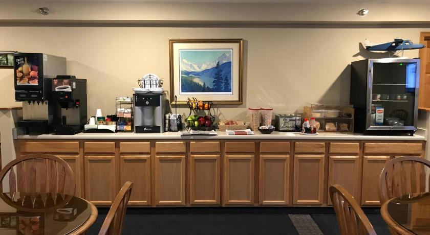 a kitchen with a table and chairs and a refrigerator, Lakeshore Inn & Suites in Anchorage (AK)
