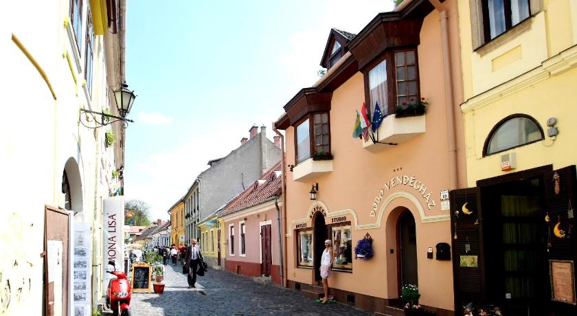 a street scene with buildings and people walking down the street, Dobo Vendeghaz in Eger