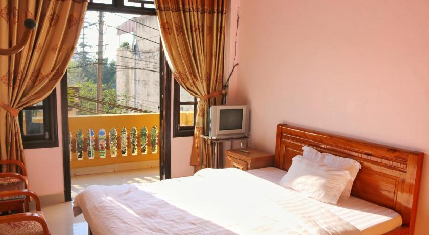 a bedroom with a bed and a television, Thanh Ha Homestay Sapa in Sapa