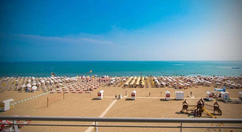 a beach filled with lots of beach chairs and umbrellas, Hotel Delle Nazioni in Caorle