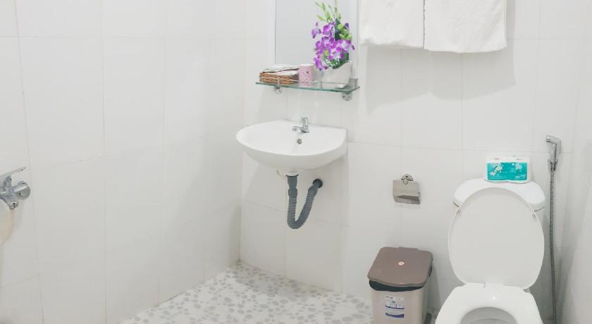 a white toilet sitting next to a white sink, hai phuong tuyen in Phu Quoc Island