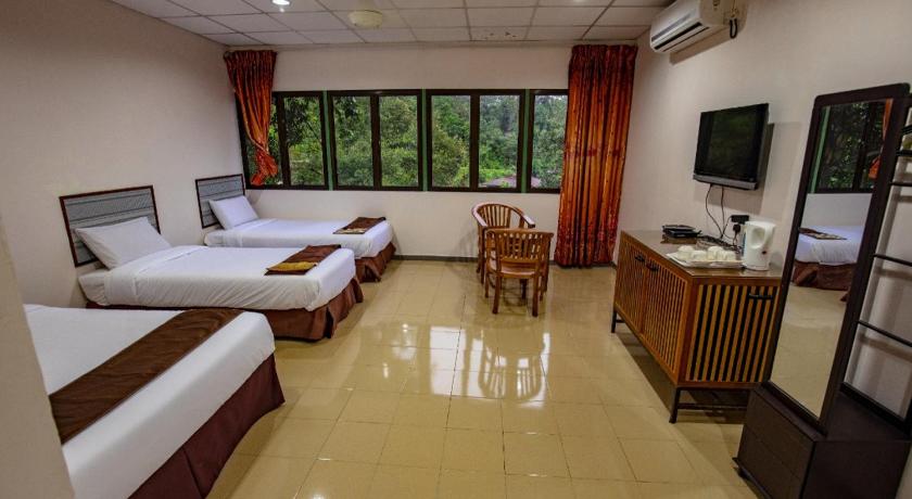 a hotel room with two beds and a television, Pollock View Resort in Sungai Lembing