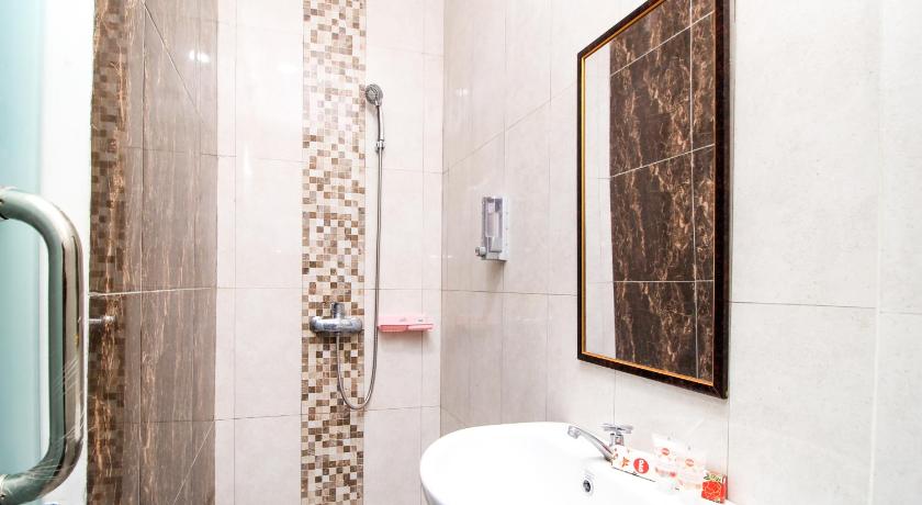 a bathroom with a toilet, sink, and mirror, Super OYO 217 A1 Hotel in Surabaya