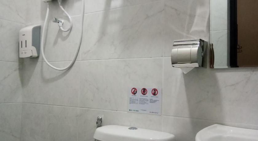 a white toilet sitting next to a white sink, Asiago Hotel in Sungai Petani